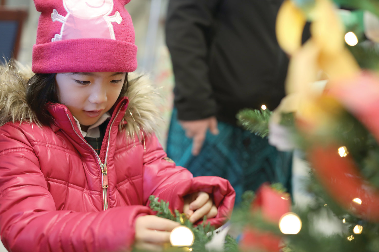Emily Lim joins her schoolmates in bringing Christmas to the Navigant Park Square Branch, across the street from Msgr. Gadoury Catholic Regional School on Dec. 5.